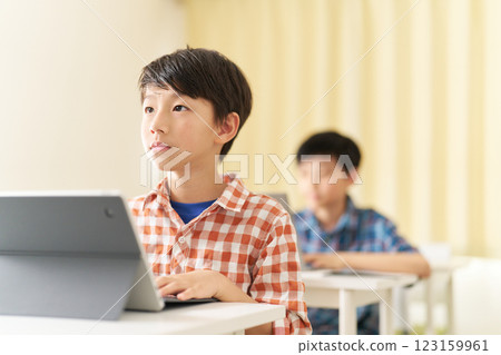 一名男小學生表情嚴肅地上課 123159961