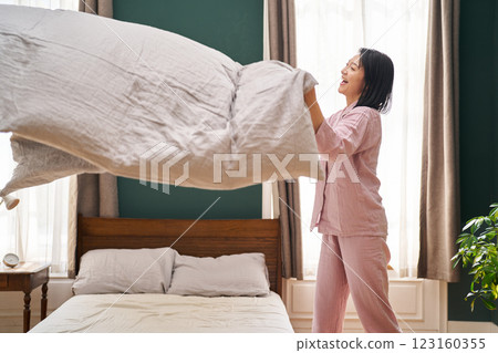 A woman wakes up in the morning and straightens out her quilt A woman wakes up in the morning and straightens out her quilt 123160355