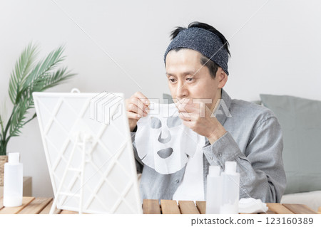 Middle-aged man using face mask, dry skin, moisturizing, face care Middle-aged man using face mask, dry skin, moisturizing, face care 123160389