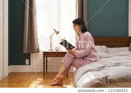 一名女子早晨起床並寫下晨間筆記 一名女子早晨起床並寫下晨間筆記 123160425