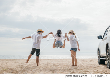 Happy family three hand in hand and jumping on sandy beach, Parents father and mother jump their children back car, holiday vacations summer road trip, Family day enjoying their time together Happy family three hand in hand and jumping on sandy beach, Parents father and mother jump their children back car, holiday vacations summer road trip, Family day enjoying their time together 123160503