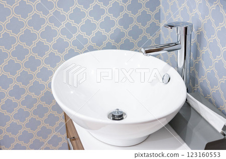 A sink and faucet that blend in with a stylish space 123160553