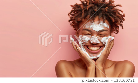 Happy young woman washing face with foaming cleanser 123160751