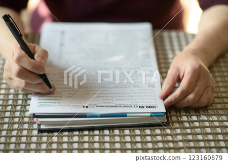 Senior Woman Filling Out Tax Form Senior Woman Filling Out Tax Form 123160879