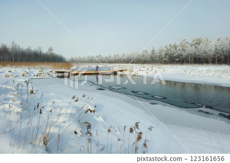 Snow and old wooden bridge over the river. 123161656