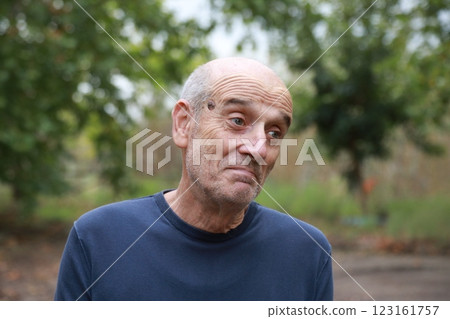 Elderly Man Makes Facial Expression Of We Hope Under A Tree In The Countryside 123161757