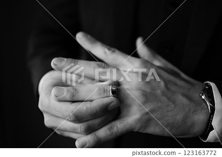 A man's hands gently hold a ring, a symbol of commitment and love. 123163772