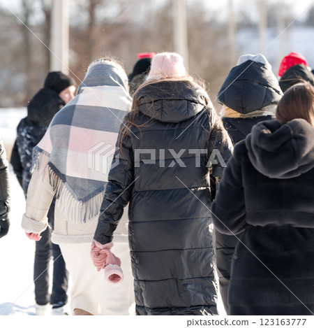 Winter stroll: People bundled up walking outdoors on a cold, sunny day. Winter stroll: People bundled up walking outdoors on a cold, sunny day. 123163777