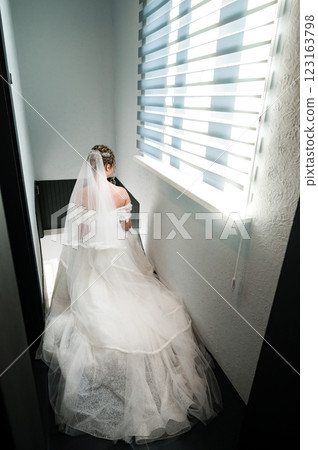 Bride in wedding gown ascending stairs, sunlight streaming through window behind. Bride in wedding gown ascending stairs, sunlight streaming through window behind. 123163798