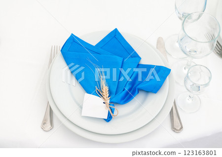 Elegant blue napkin setting with wheat decoration, ready for a formal dinner. Elegant blue napkin setting with wheat decoration, ready for a formal dinner. 123163801