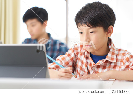 一名男小學生表情嚴肅地學習 123163884