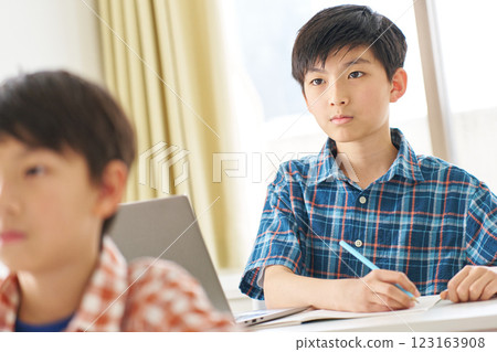 A senior boy studying with a serious expression 123163908