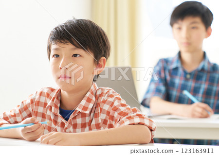 A male elementary school student studying with a serious expression A male elementary school student studying with a serious expression 123163911