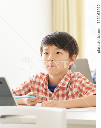 一名男小學生表情嚴肅地學習 123163912