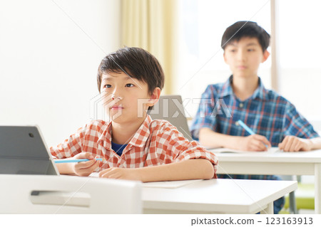 一名男小學生表情嚴肅地學習 123163913