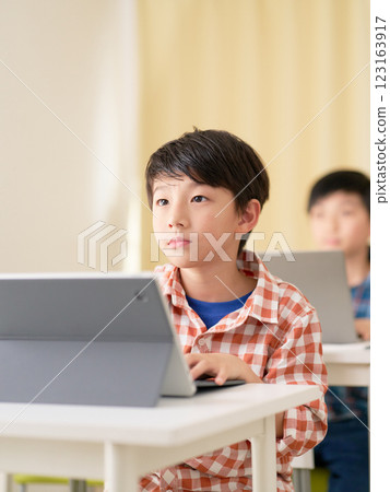 A male elementary school student taking a class with a serious expression 123163917