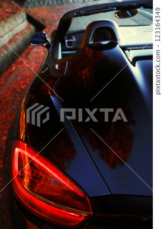 A black convertible and autumn leaves reflected in it A black convertible and autumn leaves reflected in it 123164349