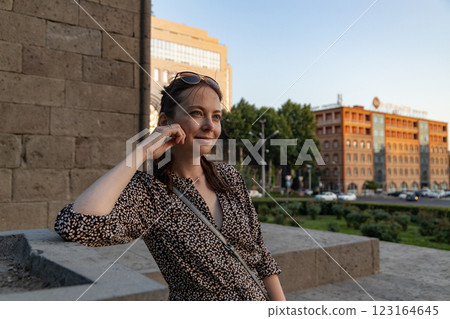 Woman enjoying a sunny day in a lively urban park surrounded by historical architecture in Yerevan 123164645