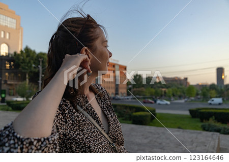 Captivating woman enjoys sunset view in vibrant cityscape during warm summer evening 123164646