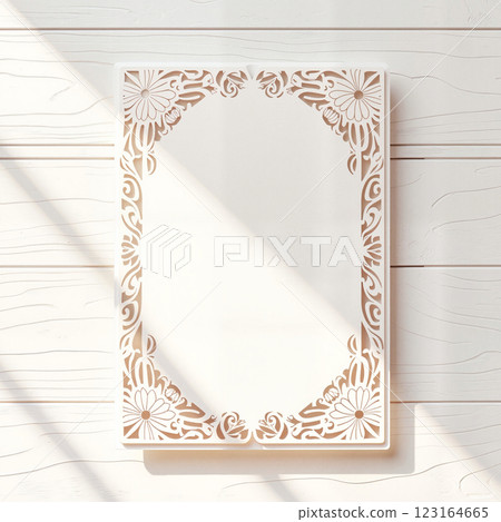Decorative paper design with intricate floral patterns on a light wooden background showcasing creative potential for invitations 123164665