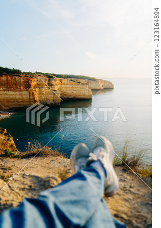 A personal perspective of a person relaxing on the cliffs of the Algarve, Portugal. Golden limestone 123164894