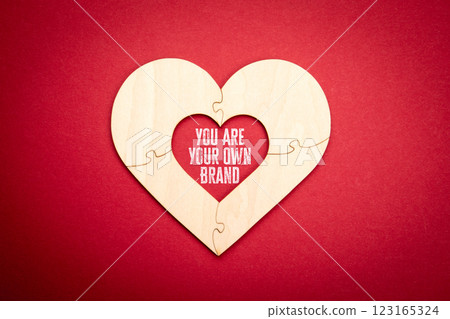 You Are Your Own Brand. Wooden puzzle in the shape of a heart on a red background 123165324
