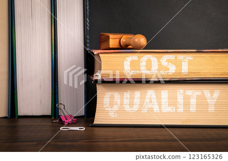 Cost and Quality. A stack of books on a wooden shelf Cost and Quality. A stack of books on a wooden shelf 123165326