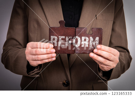REFORM Concept. Business woman with wooden puzzle pieces 123165333