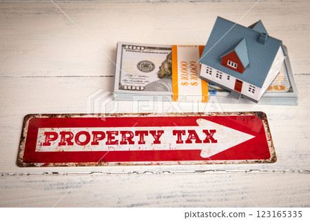 Property Tax. Red direction arrow sign on a white wooden table Property Tax. Red direction arrow sign on a white wooden table 123165335