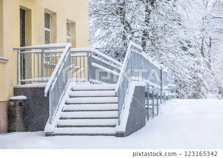 Icy and snow-covered entrance stairs. Metal structure 123165342