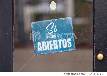 Yes, we're open - Sign written in Spanish 123166330