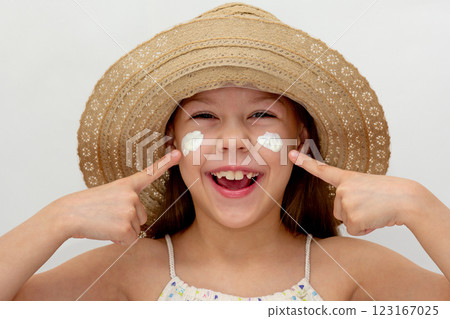 Portrait of caucasian smiling child in straw hat showing on cheeks with cream of 6 7 years looking at camera Portrait of caucasian smiling child in straw hat showing on cheeks with cream of 6 7 years looking at camera 123167025