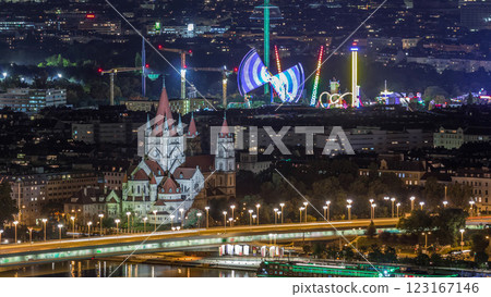 Aerial panoramic view over Vienna city with skyscrapers, historic buildings and a riverside promenade night timelapse in Austria. 123167146