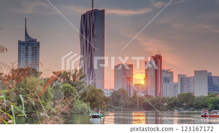 Sunset over Vienna international center skyscrapers with Kaiserwasser lake reflection view timelapse 123167172