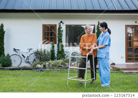 Elderly Woman with Caregiver Walking in Garden Outside Home, Enjoying Fresh Air and Nature, Senior Care and Support Concept Elderly Woman with Caregiver Walking in Garden Outside Home, Enjoying Fresh Air and Nature, Senior Care and Support Concept 123167314