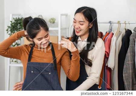 Cheerful fashion designers collaborating on clothing display in a stylish boutique 123167344
