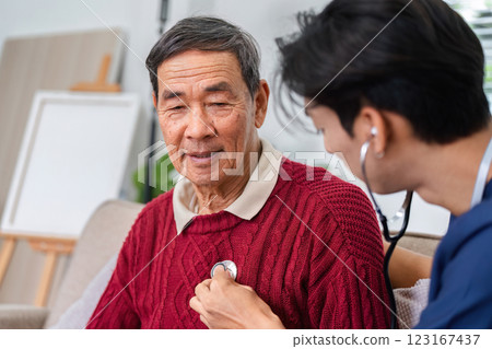 Nurse using stethoscope to check elderly man's heart during a home health check-up 123167437