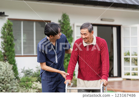 Healthcare worker and elderly man sharing a smile as they navigate outdoors with a walker 123167486