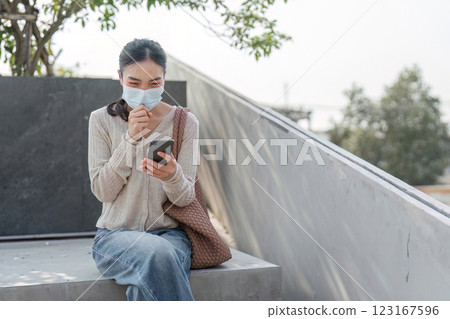 Smiling woman using smartphone while managing pollution discomfort 123167596