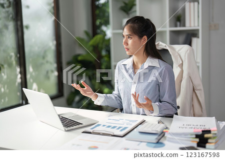 Finance worker discussing strategies during a video call in a bright office environment. 123167598