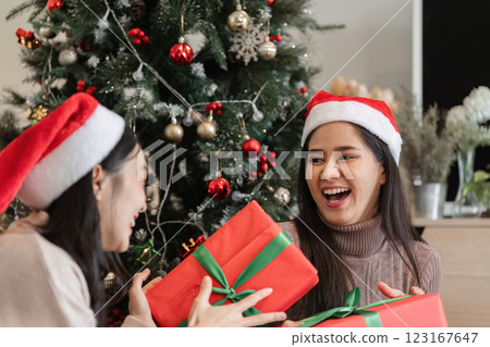 Joyful Young Couple Celebrating Christmas with Surprise Gifts in Festive Holiday Setting 123167647