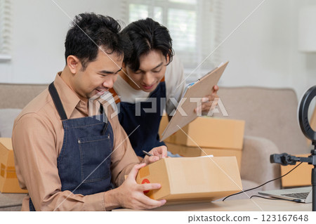 Collaborative online sellers organizing packages and discussing shipment details in a modern workspace. 123167648