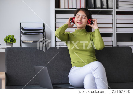 Asian woman relaxing with headphones in modern office, concept of relaxation Asian woman relaxing with headphones in modern office, concept of relaxation 123167708
