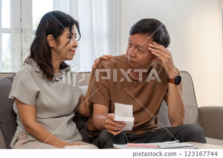 Elderly Couple Reviewing Financial Documents at Home for Retirement Planning and Budgeting 123167744