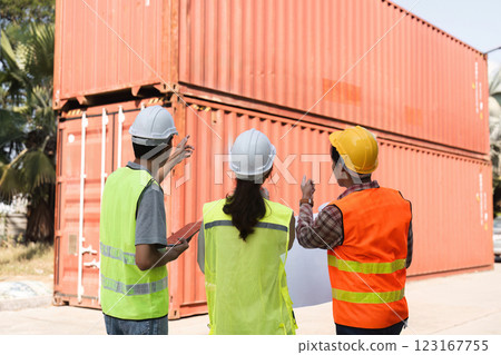 Construction team discussing logistics and planning strategies at a site with shipping containers Construction team discussing logistics and planning strategies at a site with shipping containers 123167755