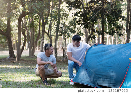 Young Asian homosexual couple spending their free time Holidays sitting together, relaxing, camping and hiking together. Young Asian homosexual couple spending their free time Holidays sitting together, relaxing, camping and hiking together. 123167933