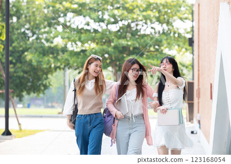 Happy Asian teenager female college student holding book and looking at nature outdoors at university Prepare for class Happy Asian teenager female college student holding book and looking at nature outdoors at university Prepare for class 123168054