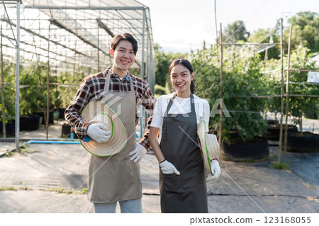 Couple Cultivating a Cannabis Herb Garden Together in a Modern Greenhouse Setting with Sustainable Gardening Techniques Couple Cultivating a Cannabis Herb Garden Together in a Modern Greenhouse Setting with Sustainable Gardening Techniques 123168055