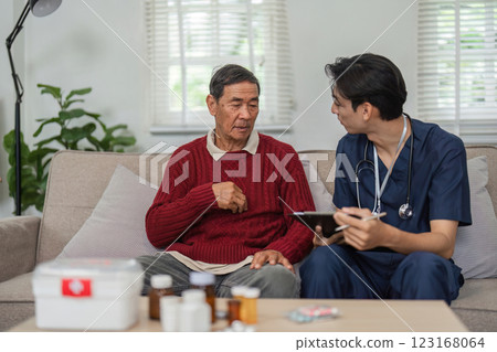 Nurse reviewing health information with elderly patient in bright living room 123168064