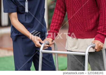 Healthcare professional assisting elderly man with walker, supporting mobility and wellbeing 123168141